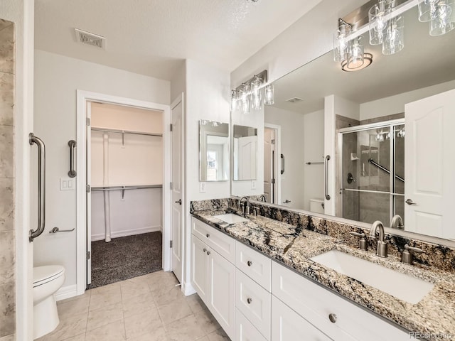 full bathroom with visible vents, a sink, a shower stall, and toilet