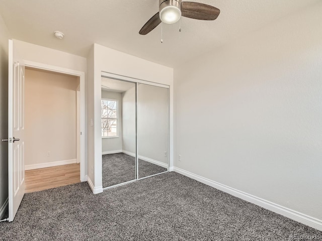 unfurnished bedroom with carpet, a closet, and baseboards