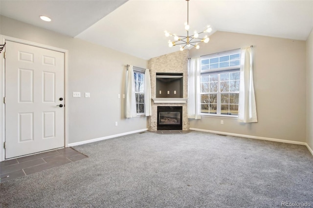 unfurnished living room with carpet, baseboards, lofted ceiling, a fireplace, and a notable chandelier