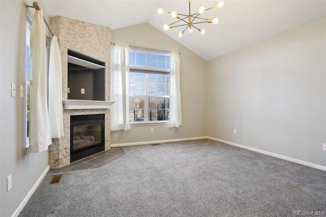 unfurnished living room with visible vents, a large fireplace, vaulted ceiling, carpet floors, and a notable chandelier