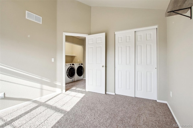 unfurnished bedroom with visible vents, a closet, separate washer and dryer, carpet, and lofted ceiling