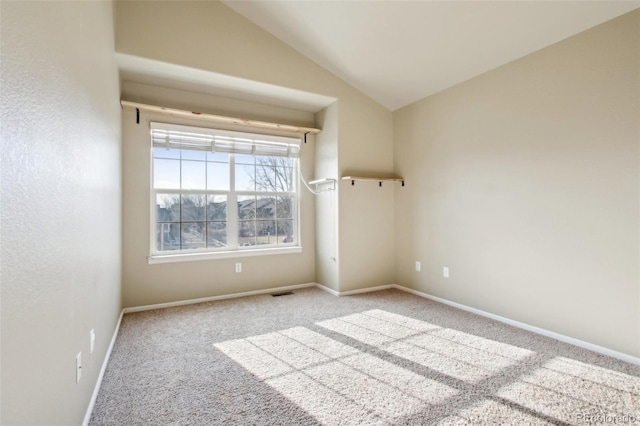 empty room featuring visible vents, baseboards, carpet flooring, and vaulted ceiling