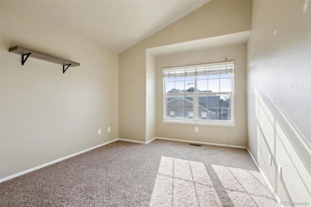 unfurnished room with baseboards, light carpet, and vaulted ceiling