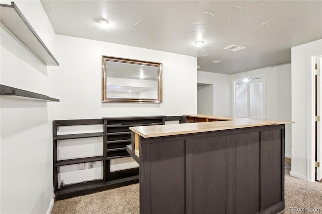 interior space featuring visible vents, light carpet, and baseboards