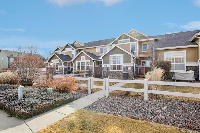 view of front of property with a residential view, stone siding, and a fenced front yard