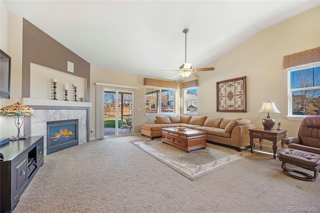 living room featuring a tile fireplace, ceiling fan, light colored carpet, and lofted ceiling