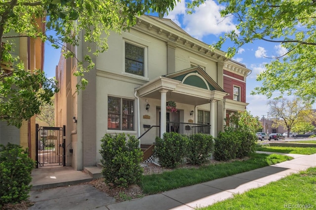 1580 N Franklin St, Denver, CO 80218 - view of front of house with a gate, a porch, and stucco siding