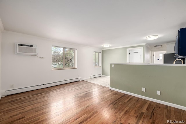 unfurnished living room with crown molding, baseboard heating, a wall mounted air conditioner, light wood-style flooring, and a baseboard heating unit