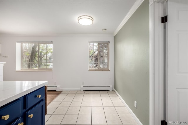 unfurnished dining area with baseboards, a baseboard heating unit, ornamental molding, and light tile patterned floors
