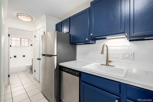 kitchen featuring crown molding, a sink, light tile patterned flooring, blue cabinets, and stainless steel appliances