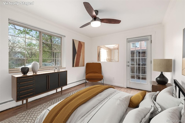 bedroom with crown molding, wood finished floors, multiple windows, and access to exterior