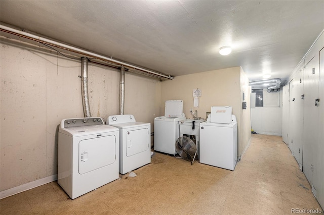 laundry area featuring laundry area, baseboards, light floors, washing machine and dryer, and electric panel