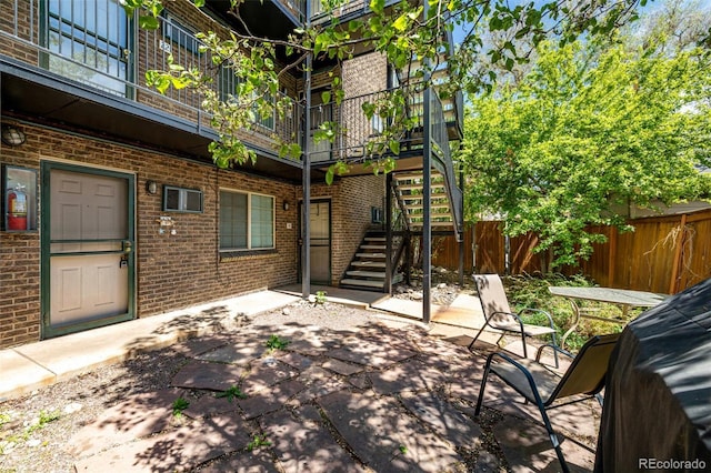 view of patio with stairway and fence