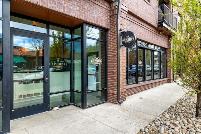 doorway to property featuring brick siding