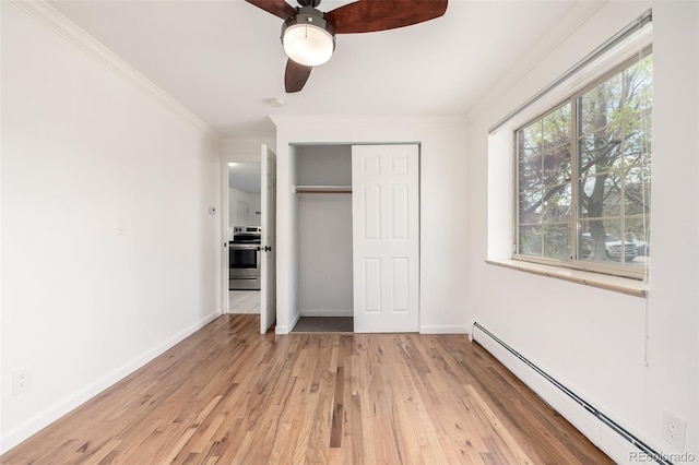 70 N Grant St Unit 10, Denver, CO 80203 - unfurnished bedroom featuring baseboard heating, ornamental molding, light wood finished floors, a closet, and baseboards