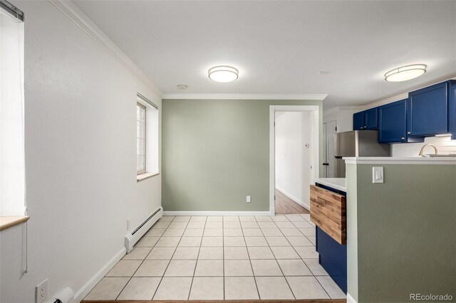 70 N Grant St Unit 10, Denver, CO 80203 - kitchen featuring blue cabinets, a baseboard heating unit, crown molding, light countertops, and light tile patterned flooring