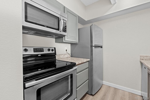 kitchen featuring appliances with stainless steel finishes, gray cabinets, and light hardwood / wood-style flooring