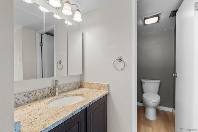 bathroom with hardwood / wood-style flooring, vanity, and toilet