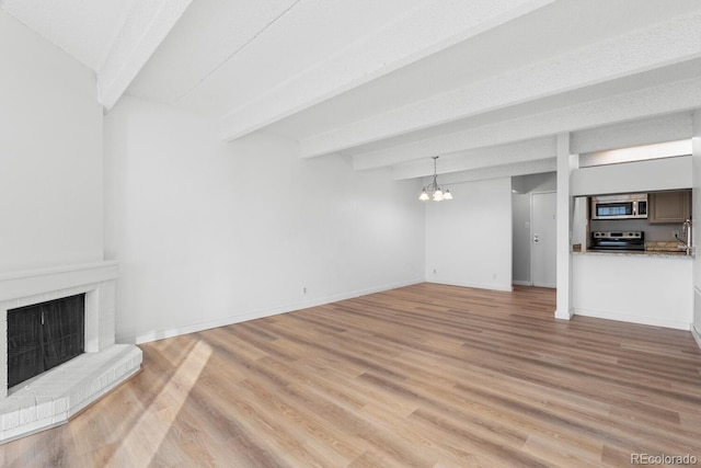 unfurnished living room featuring light hardwood / wood-style flooring, beamed ceiling, and a notable chandelier