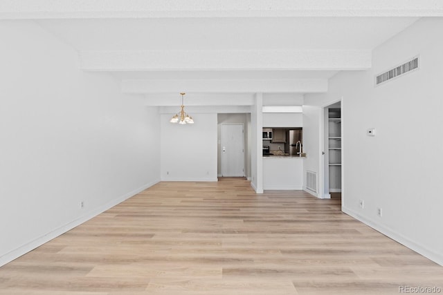 unfurnished living room with beamed ceiling, light wood-type flooring, and an inviting chandelier