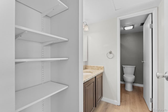 bathroom featuring hardwood / wood-style floors, vanity, and toilet