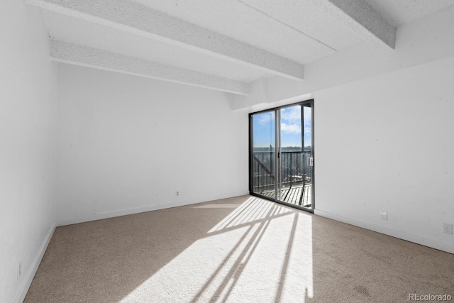 empty room featuring beamed ceiling, a textured ceiling, and carpet floors