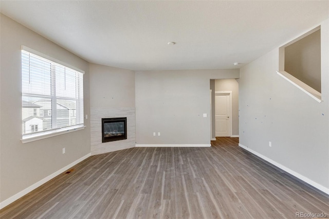 18358 Field Mint Pt, Parker, CO 80134 - unfurnished living room with a fireplace, wood finished floors, and baseboards