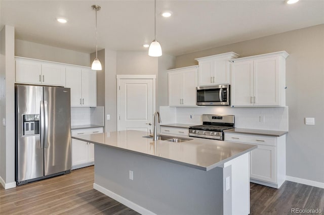 18358 Field Mint Pt, Parker, CO 80134 - kitchen featuring a sink, a center island with sink, baseboards, wood finished floors, and appliances with stainless steel finishes