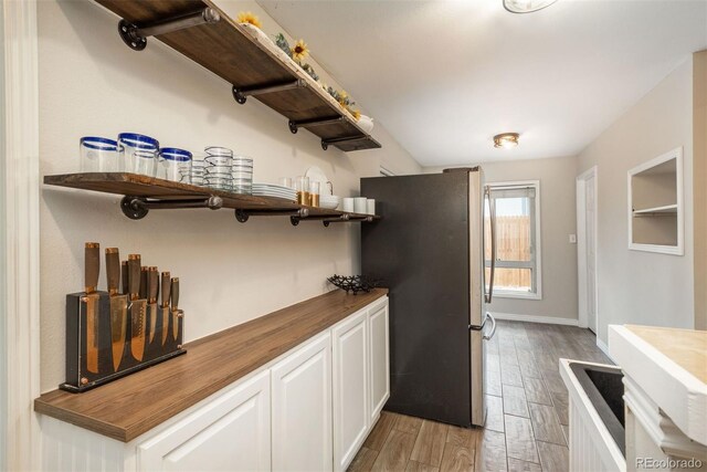 1264 Uinta St, Denver, CO 80220 - kitchen with open shelves, freestanding refrigerator, wooden counters, light wood-style floors, and white cabinetry