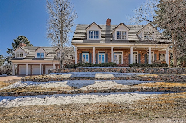 view of front of property featuring a porch, brick siding, and a chimney