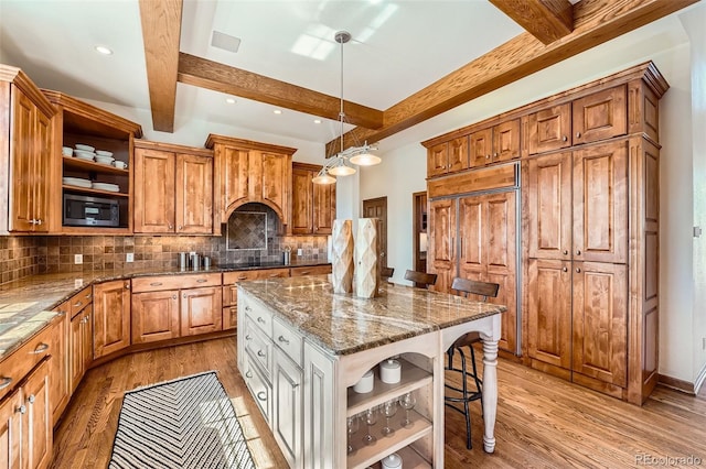 kitchen with a breakfast bar area, light wood-style floors, and open shelves