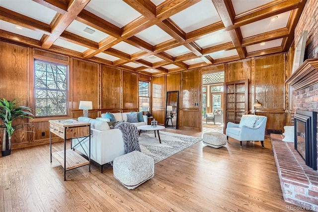 living room featuring plenty of natural light, beam ceiling, and light wood finished floors