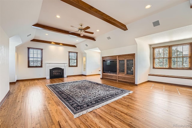 living area featuring beamed ceiling, a ceiling fan, a baseboard heating unit, wood-type flooring, and baseboards