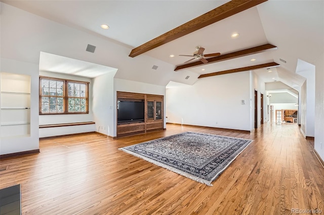 living area with a ceiling fan, lofted ceiling with beams, wood finished floors, and baseboards