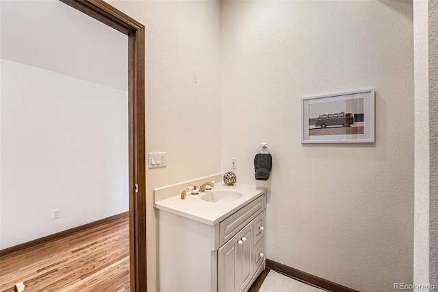 bathroom featuring vanity, baseboards, and wood finished floors