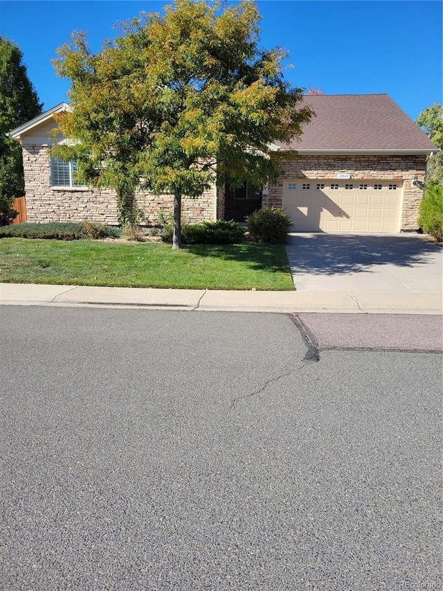 obstructed view of property with a garage and a front lawn