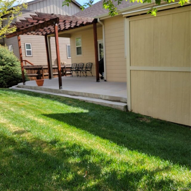 back of property featuring a patio, a yard, and a pergola