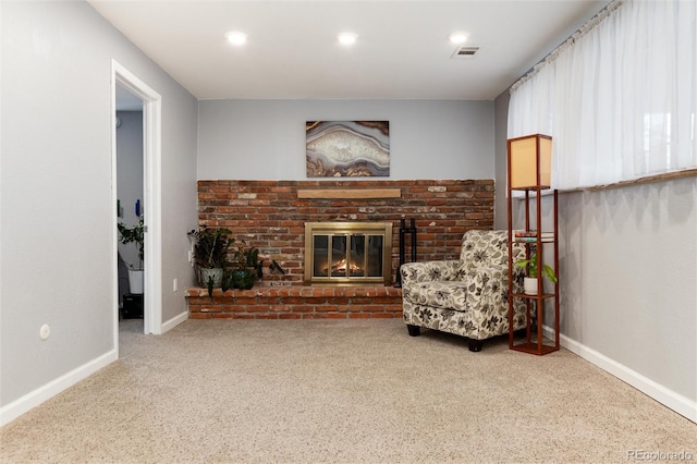 living area featuring baseboards, a brick fireplace, visible vents, and carpet flooring