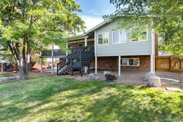 8063 S Otis Ct, Littleton, CO 80128 - rear view of house with a wooden deck, fence, stairs, brick siding, and a yard
