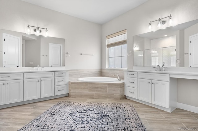 8691 S Sicily Ct, Aurora, CO 80016 - full bathroom with a bath, two vanities, and wood finished floors
