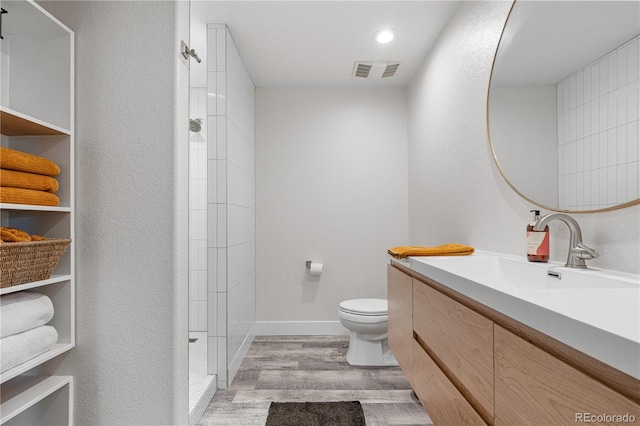 8691 S Sicily Ct, Aurora, CO 80016 - bathroom with wood finished floors, toilet, tiled shower, vanity, and recessed lighting