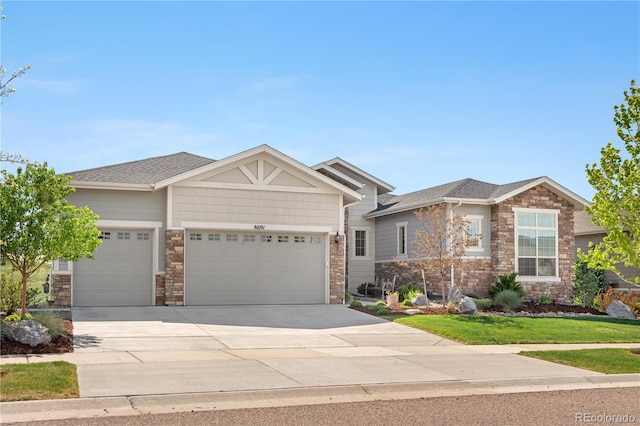 8691 S Sicily Ct, Aurora, CO 80016 - view of front of home with an attached garage, stone siding, concrete driveway, and roof with shingles