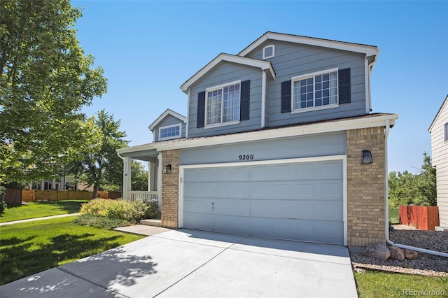 9200 W Indore Dr, Littleton, CO 80128 - traditional-style house with an attached garage, driveway, and brick siding