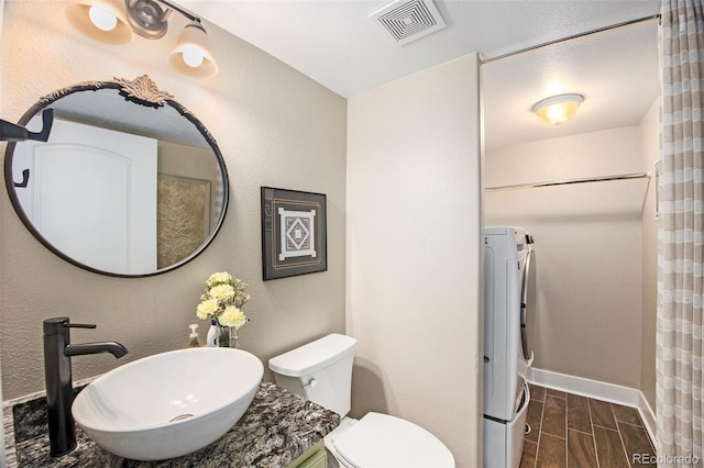 9200 W Indore Dr, Littleton, CO 80128 - full bathroom with washer / dryer, wood tiled floors, and vanity