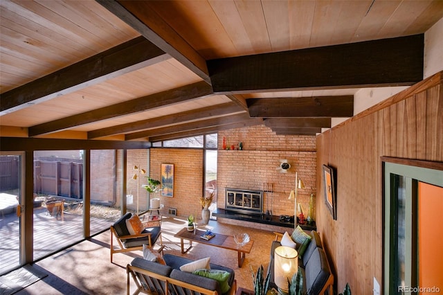 living room with vaulted ceiling with beams, a brick fireplace, and wooden ceiling