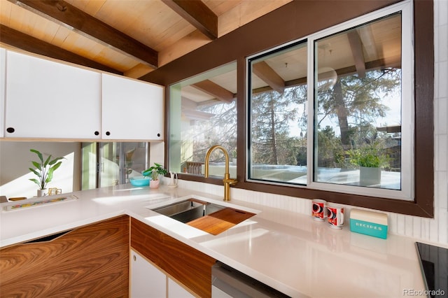 kitchen with lofted ceiling with beams, sink, white cabinets, and wood ceiling