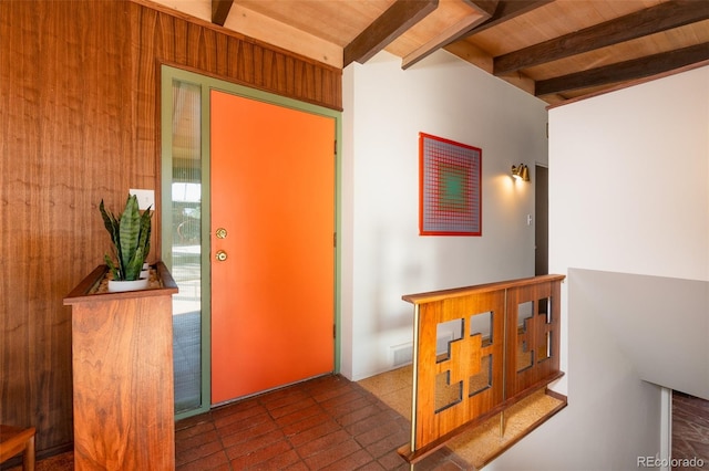 foyer entrance with vaulted ceiling with beams, wooden ceiling, and wooden walls