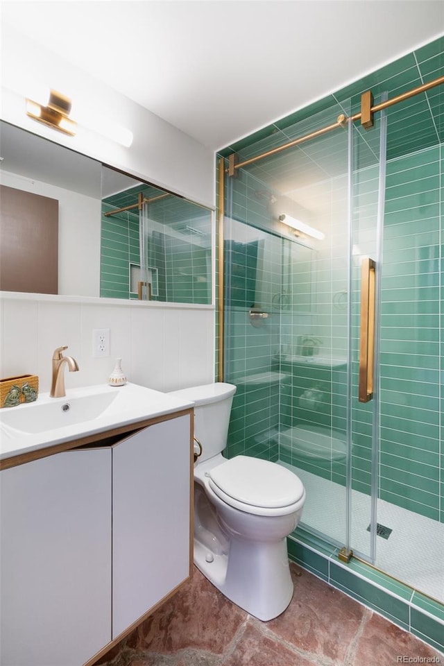 bathroom featuring tasteful backsplash, walk in shower, vanity, tile walls, and toilet