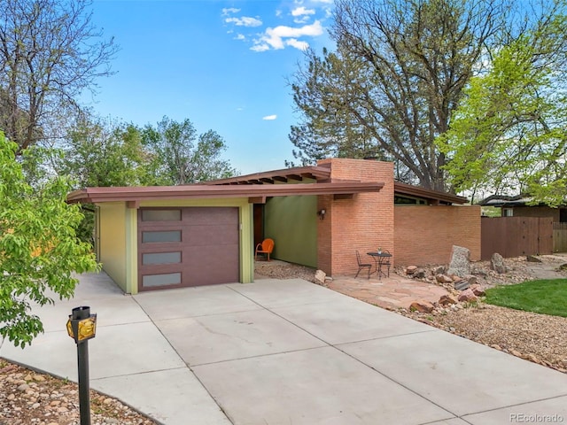 5450 Mohawk Rd, Littleton, CO 80123 - view of front facade featuring concrete driveway, fence, and a garage