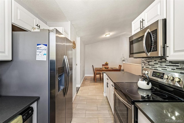 9605 Orangewood Dr, Thornton, CO 80260 - kitchen featuring stainless steel appliances, dark countertops, white cabinets, backsplash, and a textured ceiling
